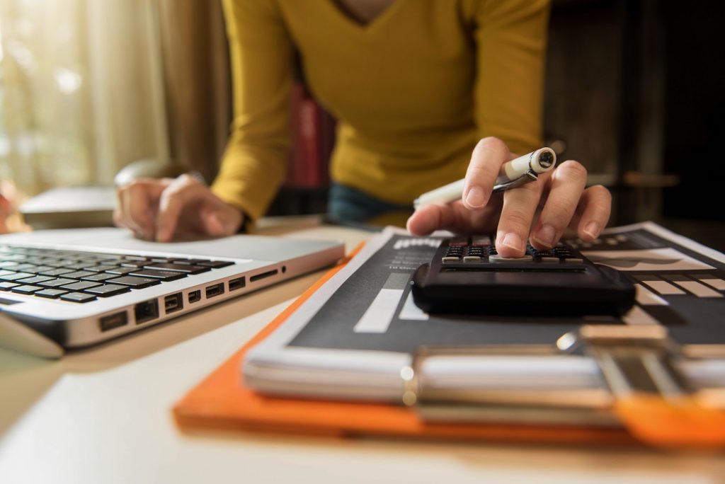 Businessman calculates financials with graph paper on the table on the cost of home office: supreme smp Businessman calculates financials with graph paper on the table on the cost of home office